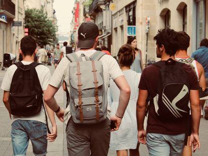 Varios adolescentes andan por la calle.