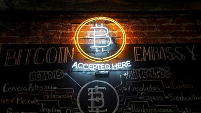 Un neón con el símbolo del bitcoin brilla en un bar de México.