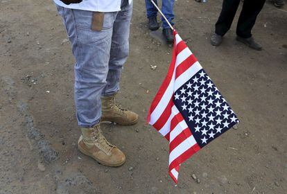 Un hombre con una bandera de Estados Unidos espera la llegada del presidente de Estados Unidos a Nairobi, Kenia.