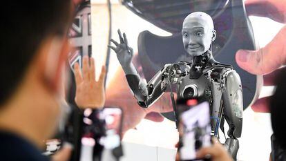 Attendees take pictures and interact with the Engineered Arts Ameca humanoid robot with artificial intelligence as it is demonstrated during the Consumer Electronics Show (CES) on January 5, 2022 in Las Vegas, Nevada. (Photo by Patrick T. FALLON / AFP) (Photo by PATRICK T. FALLON/AFP via Getty Images)