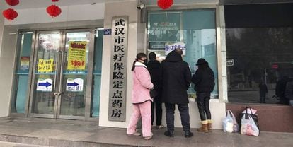 Ciudadanos hacen cola ante una farmacia en Wuhan, China.