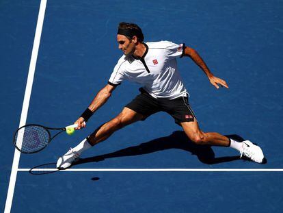 Federer devuelve la pelota durante el partido contra Evans.