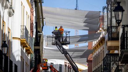 Operarios trabajan en la colocación de toldos para aliviar el calor en el centro de Sevilla, el 10 de abril.