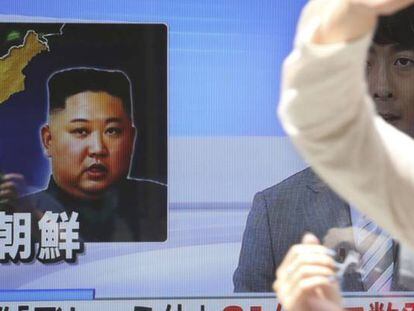 Dos personas caminan el Seul delante de un televisor donde se informa de las últimas pruebas militares realizadas por Corea del Norte.