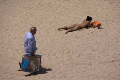 Una joven practica toples en la playa de la Victoria, Cadiz.
