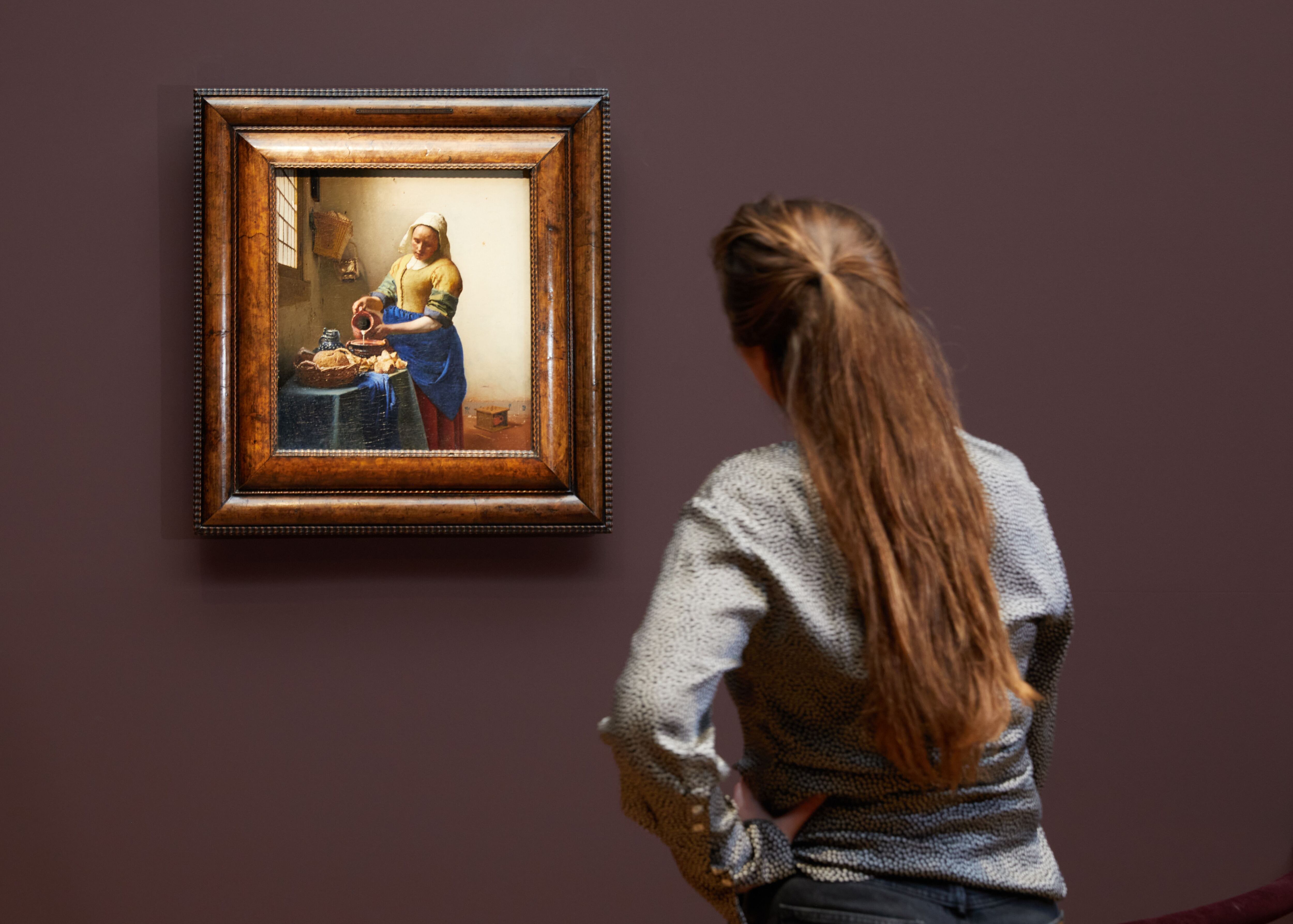 Una visitante observa 'La lechera' de Vermeer en una exposición dedicada al pintor en el Rijksmuseum.
