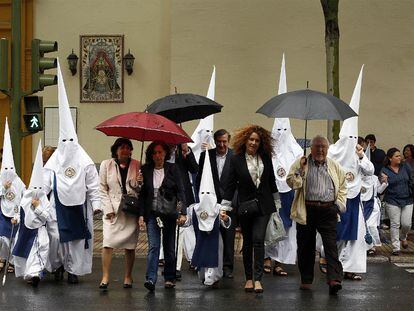 Un grupo de nazarenos dirigía a la iglesia antes de que la procesión se cancelara por la lluvia que aguó el Jueves Santo de Sevilla en 2011.