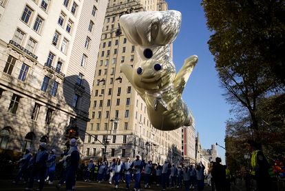 En esta ocasión, el desfile ha contado con 16 globos gigantes, 28 carrozas, 12 bandas de música, 700 payasos y un Santa Claus. En la imagen, un globo del muñeco de masa de la empresa Pillsbury sobrevuela la avenida Central Park de Nueva York. 