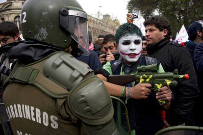 Un estudiante juega con una pistola de mentira frente a policías durante las protestas en Santiago de Chile. El país ha vivido una huelga nacional de 48 horas, la primera que sufre el Gobierno de Sebastián Piñera.