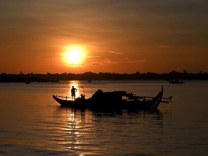 Un pescador lanza sus redes de pesca desde un barco en el río Mekong, situado en Phnom Penh.