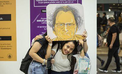 Visitantes de la FIL posan con una caricatura de Amin Maalouf.