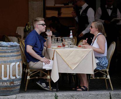 Dos turistas comen en la terraza de un restaurante del centro de Roma