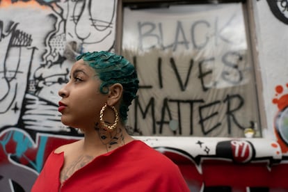 Una mujer que apoya el movimiento Black Lives Matter camina por Sweet Auburn.