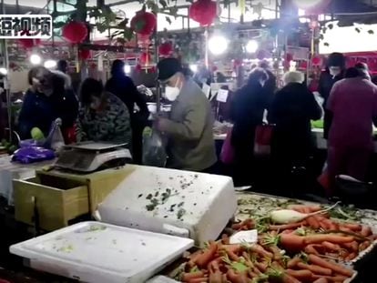 Compradores portan mascarillas en un mercado de la ciudad de Wuhan, en China.