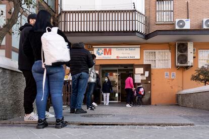 Un grupo de personas esperan en la puerta de un centro de salud de Madrid.