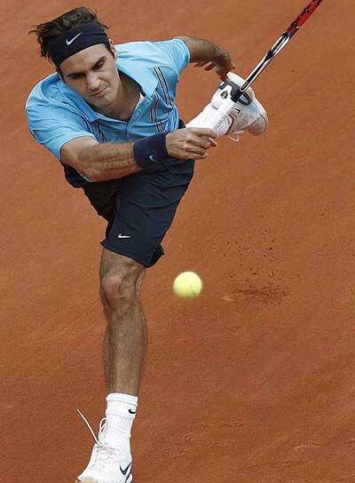 Roger Federer corre para devolver la pelota.