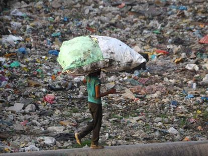 Un hombre transporta una bolsa llena de plástico reciclable cerca en Nueva Delhi el pasado mayo.