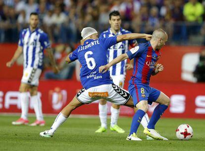 Iniesta (derecha), del Barcelona, es presionado por Marcos Llorente.