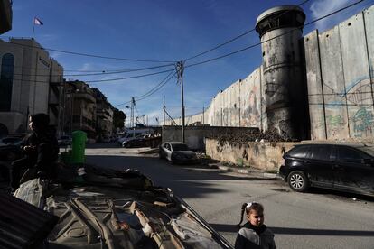 Una niña juega frente a la puerta de su casa delante del muro levantado por Israel. 
