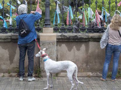 Gent collant llaços multicolors a la Ciutadella.