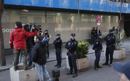 Polic&iacute;as y medios de comunicaci&oacute;n ante la inminente llegada de Mariano Rajoy a la sede del Partido Popular en Madrid.