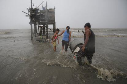 Una familia rescata sus pertenencias de entre los restos que ha dejado el fifón Koppu a su paso por Navotas al norte de Manila.