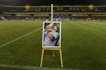 Diego Maradona besa la Copa del Mundo ganada por Argentina en 1986 en una foto colocada sobre el césped del estadio de Rosario Central, en la provincia de Santa Fe, en la previa de un partido ante River Plate disputado el 28 de noviembre de 2020.