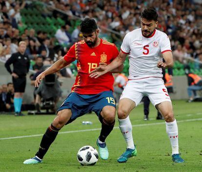 El delantero de la selección española, Diego Costa disputa el balón ante el defensa de Túnez, Oussama Haddadi.