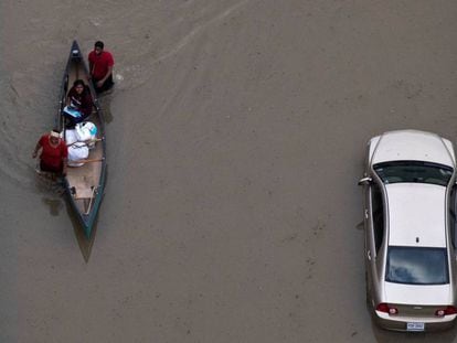 Habitantes de Houston navegan el miércoles por la ciudad inundada. En vídeo, la ONU vincula la potencia del huracán 'Harvey' al cambio climático.