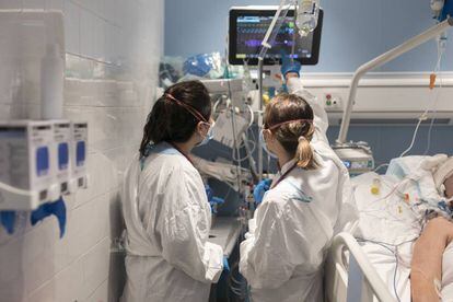 La doctora Ana Zapatero (dreta) i una altra sanitària atenen Raquel Txavarria a la UCI de l'Hospital del Mar de Barcelona.