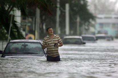 Un habitante de Cayo Hueso (Florida) camina por una calle anegada tras el paso del huracán Wilma.