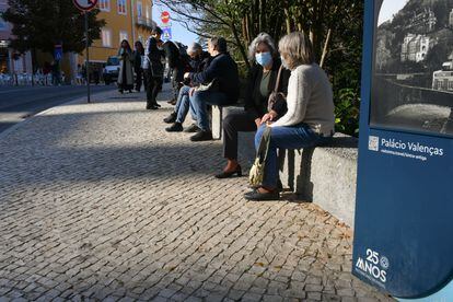 Varias personas conversan sentadas en el centro histórico de Sintra (Portugal).
