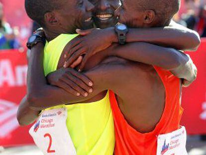 Los kenianos Kipchoge, Kittwara y Chumba se abrazan tras cruzar la meta del maratón de Chicago.