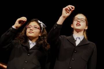 Dos niñas muestran uno de los quintos premios en el Teatro Real.