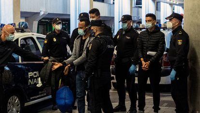 Dos jóvenes migrantes marroquíes esposados llegan al aeropuerto de Las Palmas (Gran Canaria) para ser deportados por la Policía, en diciembre de 2020.
