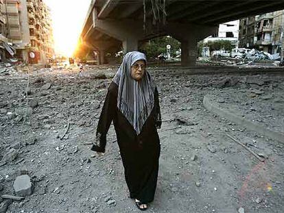 Una mujer sortea los escombros bajo una de las autovías de Beirut destruidas por la aviación israelí.