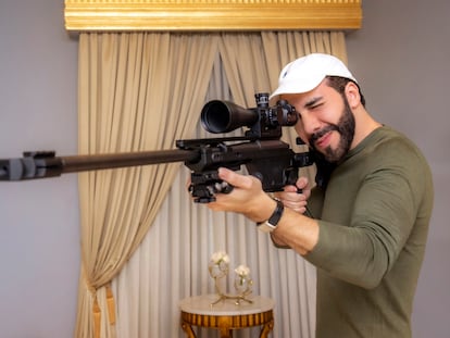 Nayib Bukele, juega con un rifle de francotirador en su oficina, en octubre de 2023.