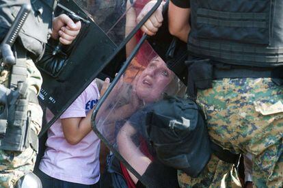 A la imatge, una dona mira com la policia bloqueja un grup de refugiats que fan la ruta Macedònia-Grècia. El primer d'aquests països va declarar l'estat d'emergència el 20 d'agost, aclaparat pel nombre d'immigrants que arribaven al seu país, i va mobilitzar el seu Exèrcit perquè vigilés la frontera.