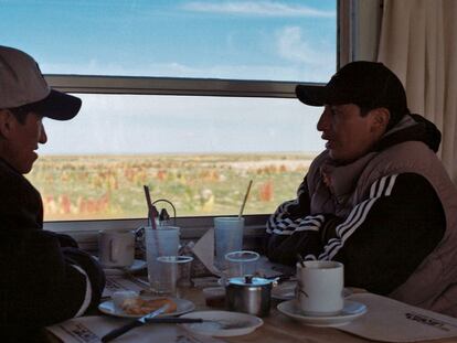 Cerca de Challapata, dos bolivianos conversan en el vagón restaurante del Wara Wara del Sur, uno de los trenes que atraviesa el altiplano, con campos de quinua al fondo.