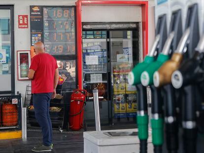 Un hombre mira los precios de una gasolinera.