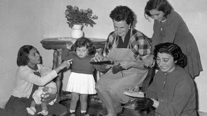 Una madre junto a sus hijas limpiando los zapatos de la familia, en una imagen de archivo de los años 60.