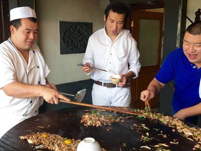 Shao Bao y sus dos cocineros durantes los toques finales de la barbacoa.