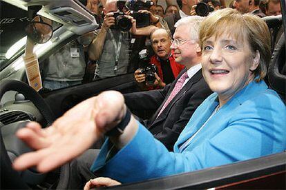 Su rival, Angela Merkel, prueba un Smart junto a Roland en el Salón del Automóvil de Francfort.
