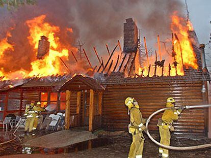Los bomberos tratan de extinguir el fuego en una casa de Lake Arrowhead, en California.