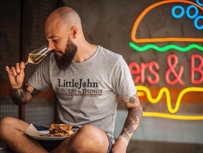 El sumiller Juan Ruiz cata un champán en su establecimiento Little John, donde marida sus hamburguesas gourmet con diversos vinos.