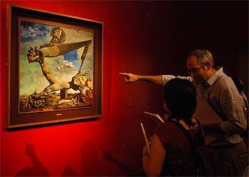 Dos visitantes, ayer, ante <i>Construcción blanda con judías hervidas. Premonición de la Guerra Civil</i> (1936), obra de Dalí expuesta en Venecia.
