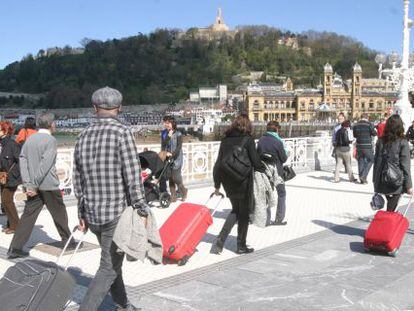 Varios turistas, en el paseo de La Concha en San Sebastián.