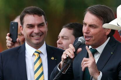 El senador Flavio Bolsonaro (a la izquierda), acompaña a su padre, el presidente de brasileño Jair Bolsonaro, en un evento de noviembre del año pasado.