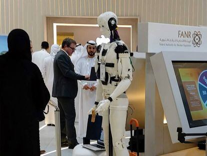 Visitantes a la feria tecnológica Gitex de Dubái conversan en presencia de un robot el pasado octubre.