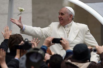 El papa Francisco coge una flor lanzada por un devoto en la plaza de San Pedro, en el Vaticano.